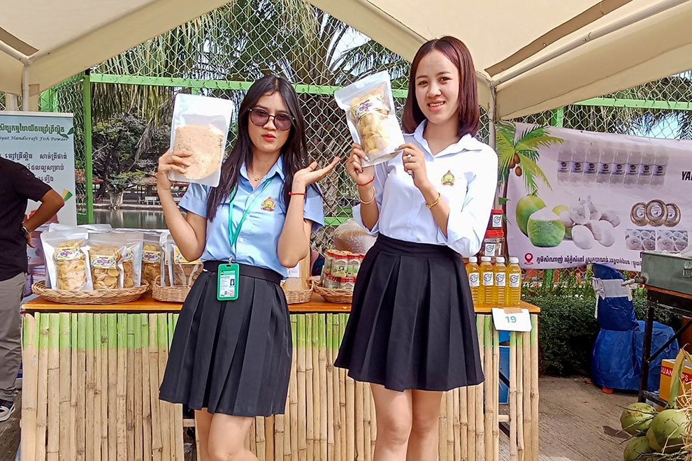 Students show off delicious and nutritious fishmeal vegetable cakes at an exhibition of Cambodian products. Hyfp FB