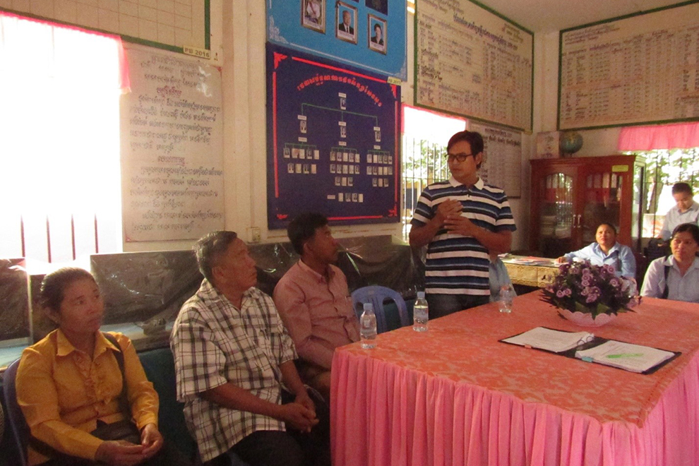 James Purthree (centre right) and Bong Mai (centre left) discuss their plans for a new water treatment system with Sen Sok community leaders. WOLPC