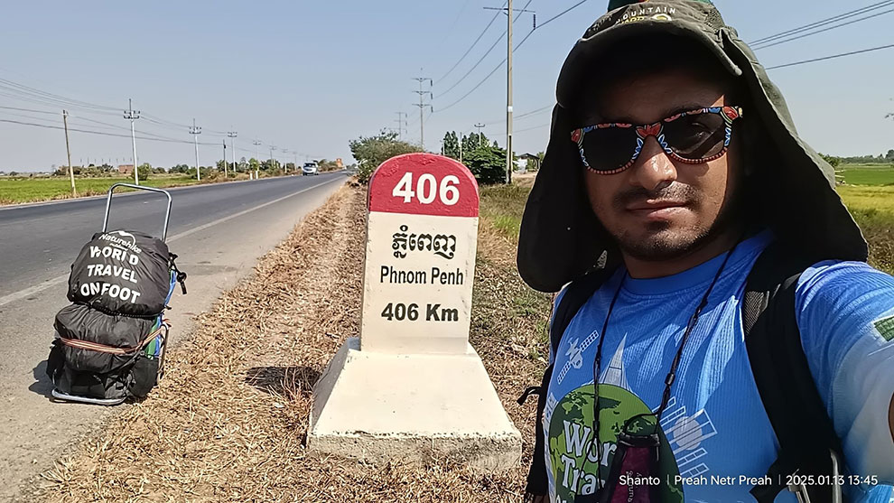 Shanto takes a selfie with his backpack at a kilometre marker on National Road 6. Supplied