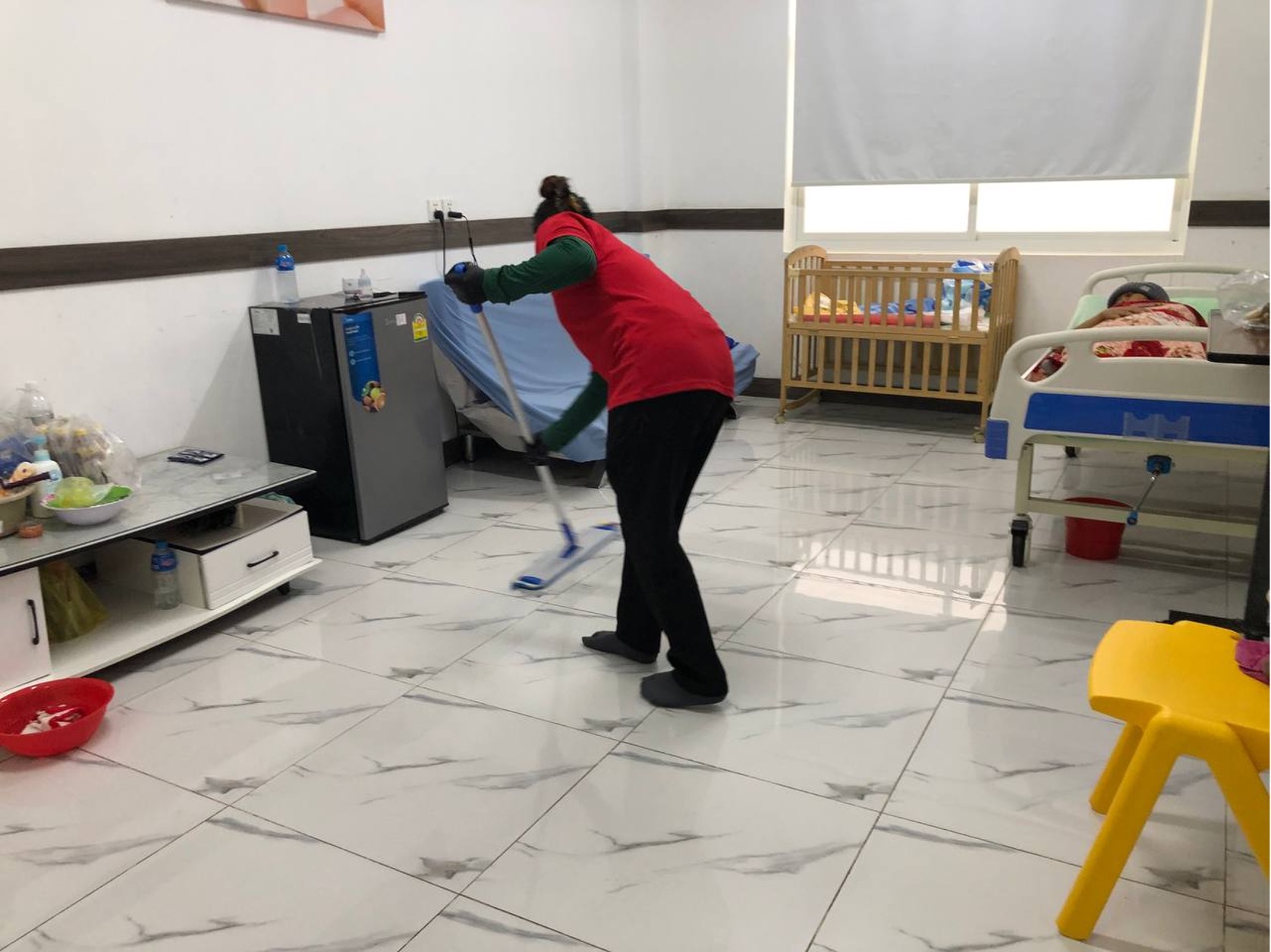 Srey Net cleans a floor in the hospital’s maternity ward. Niem Chheng