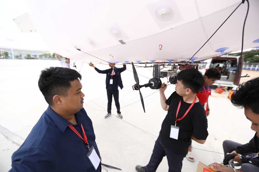 Hem Sothirith (left) addresses his team as they prepare to launch their aircraft. PHOTO SUPPLIED